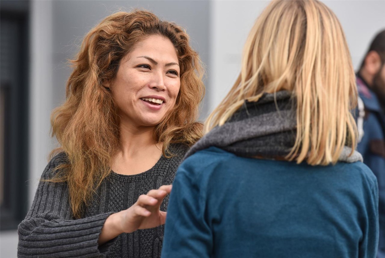 Flüchtlingsfrau und Helferin lachen