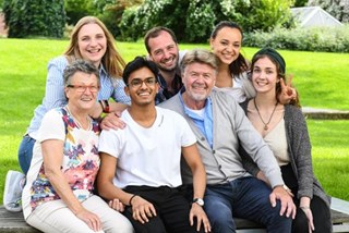 junge freiwillig Engagierte fotografieren sich zusammen mit älteren Menschen mit dem Smartphone 