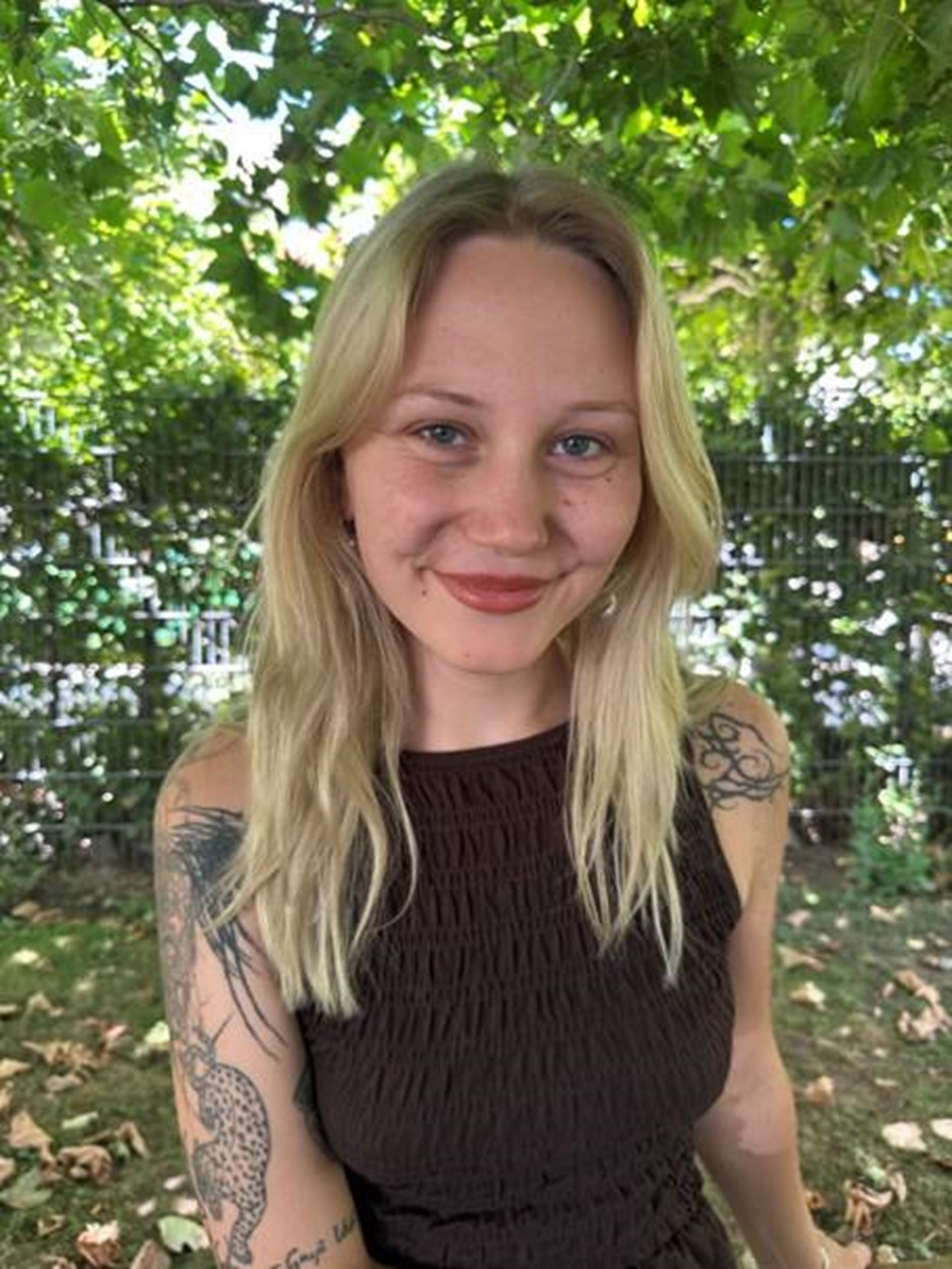 Eine blonde Frau mit langen Haaren lächelt in die Kamera. 